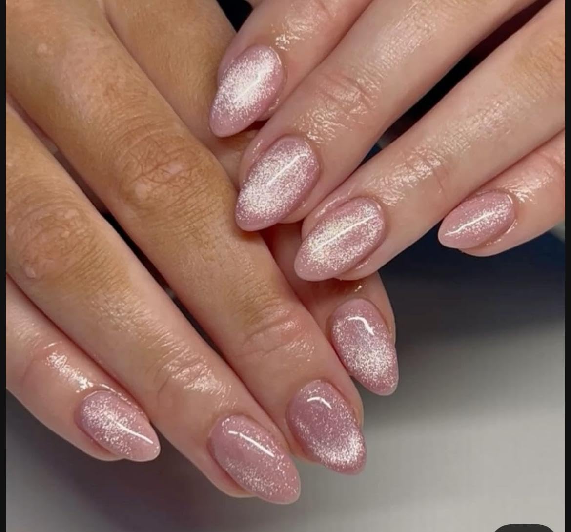 Blush-rose cat-eye nails on clasped hands